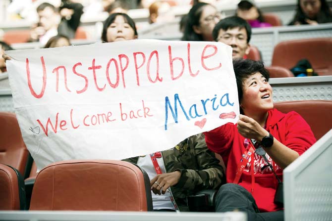 Maria Sharapova supporters hold placards during her China Open match against Ekaterina Marakova of Russia in Beijing yesterday