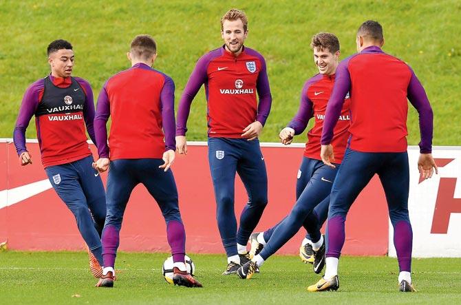 England midfielder Jesse Lingard (left) striker Harry Kane (centre) and defender John Stones (second from right) during a training session yesterday ahead of their World Cup qualifier against Slovenia tonight. The Three Lions will then play Lithuania on October 8. Pic/AFP