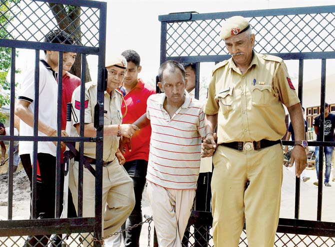 Bus conductor Ashok Kumar, who is accused of killing Thakur, being escorted by police. Pic/PTI