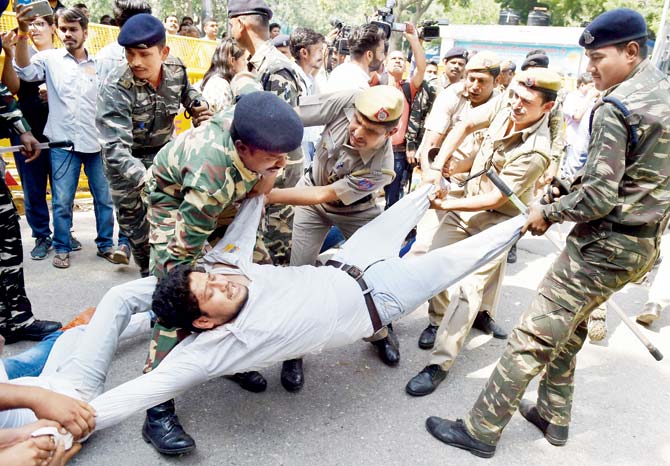 Security men detain ABVP members who were protesting in support of Banaras Hindu University (BHU) girls