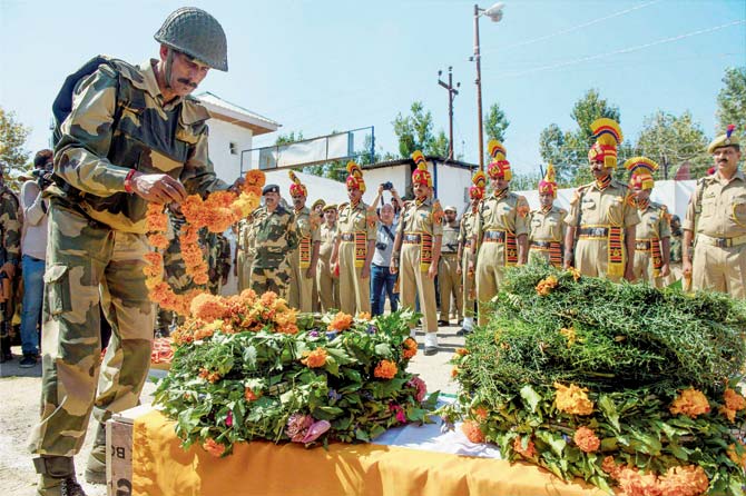 A BSF personnel pays tribute to slain colleague Rameez Ahmad Parray. Pic/PTI