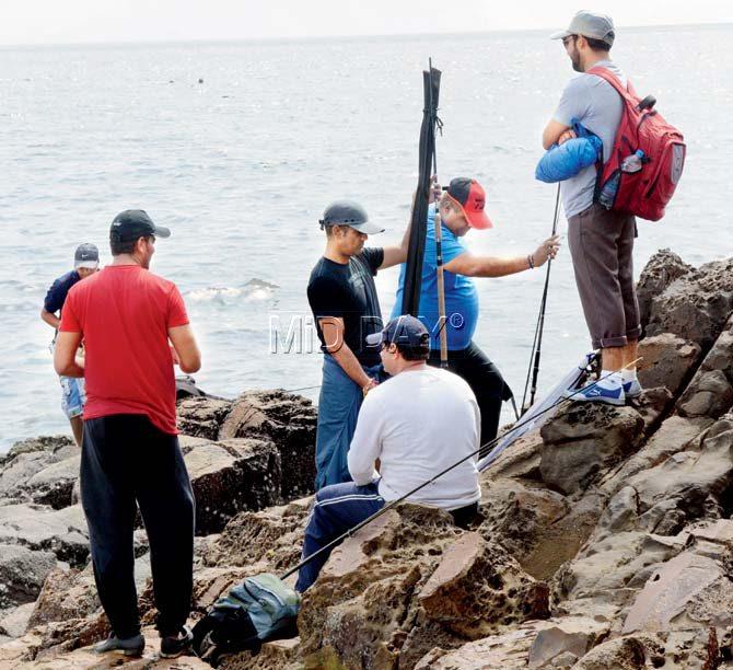A group of anglers fix their fishing rods in Madh Island