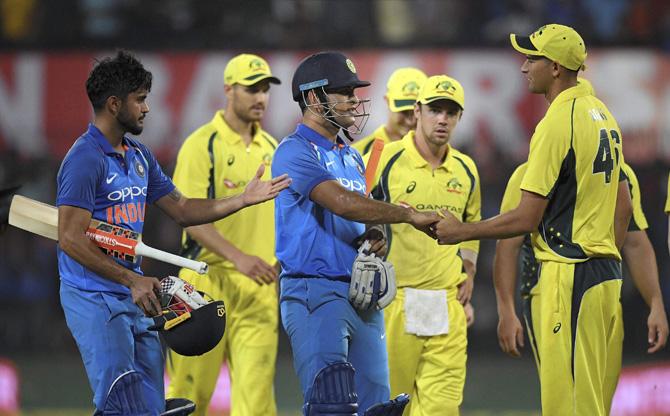 Indian Cricketer M S Dhoni with Manish Pandey shakes hand with Australian players after win the 3rd one day international (ODI) cricket match against Australia at Holkar Stadium in Indore on Sunday. Pic/PTI