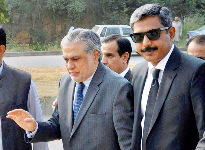 Ishaq Dar arrives with his lawyer, Amjad Pervez, to appear in court, in Islamabad, on Monday. Pic/PTI