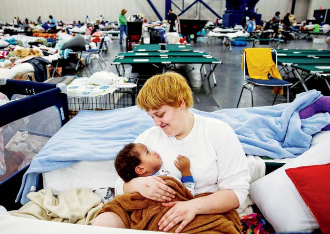Another looks after her nephew at a convention centre in the city, where 10,000 have taken shelter