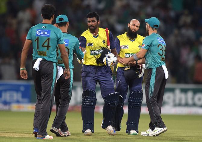 World XI batsmen Hashim Amla (2R) and Thisara Perera (C) shake hand with Pakistani cricketers at the end of the second Twenty20 international cricket match between the World XI and Pakistan at The Gaddafi Cricket Stadium in Lahore on September 13, 2017. Pakistan, who won the toss and elected to bat, made 174-6 in the second Twenty20 international against the World XI at Gaddafi Stadium on September 13. Pic/AFP