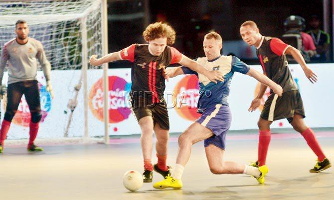 Mumbai Warriors captain Ryan Giggs (centre) battles for the ball with Delhi Dragons players during the Premier Fustal opening match at NSCI Dome, Worli yesterday. Dragons won 4-3. Pic/Bipin Kokate