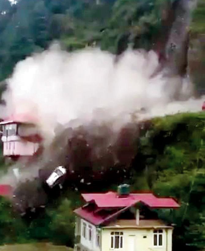 Video grab of cars rolling down the slope with rubble and boulders