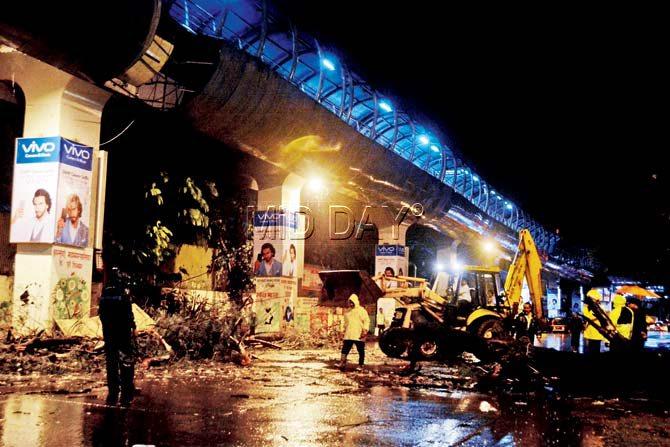 BMC workers at the site where the thundershowers damaged a portion of the skywalk near Agarkar chowk, Andheri station junction