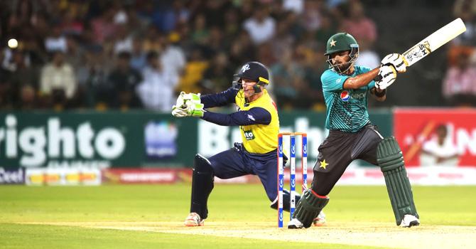 Pakistani batsman Babar Azam (R) plays a shot as World XI wicketkeeper George Bailey looks on during the third and final Twenty20 International match between the World XI and Pakistan at the Gaddafi Cricket Stadium in Lahore on September 15, 2017. Pic/AFP