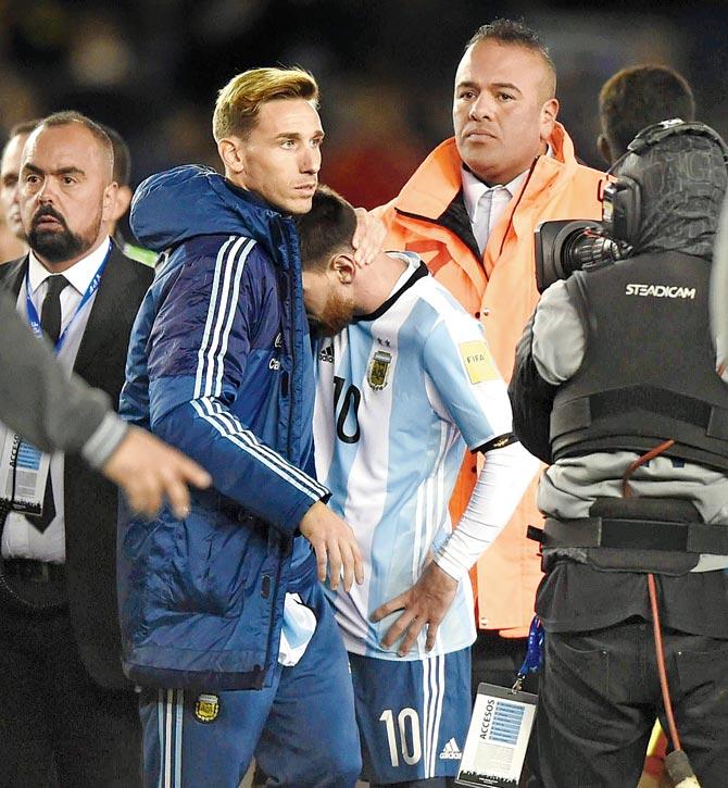 A dejected Lionel Messi (right) after Argentina’s 1-1 draw to Venezuela in Buenos Aires on Tuesday. Pic/AFP