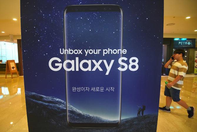 A man walks past an advertisement for the Samsung Galaxy S8 at the company