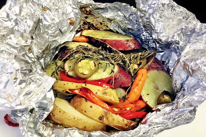 You first wrap the marinated veggies in silver foil and cover it with dough. Then place it on a tawa and cook it in sand 