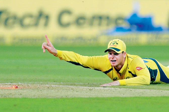 Australia skipper Steve Smith comes up with a brilliant stop at the Chinnaswamy Stadium in Bangalore yesterday. Pic/AFP