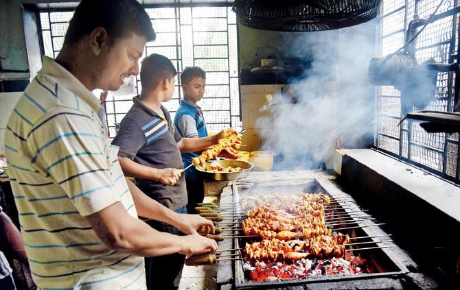 Staff members barbecue chicken at Agashi Bhujing Centre