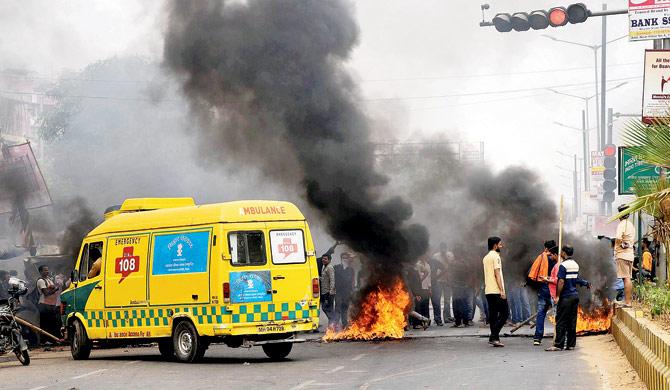 Members of Kshatriya Vikas Samith burn a tyre during the anti-quota bandh, in Patna, on Tuesday. Pic/PTI