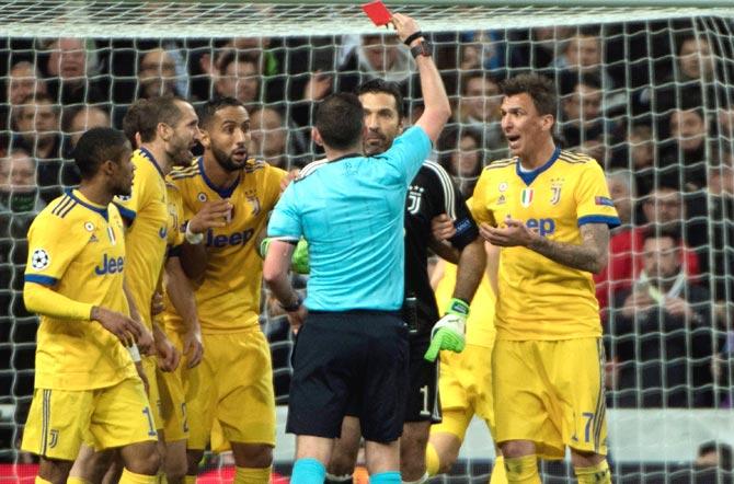 English referee Michael Oliver (4L) shows a read card to Juventus