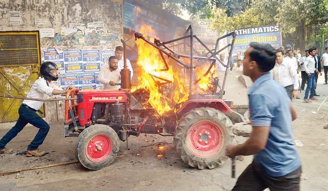 A tractor set on fire by a group of protesters during the bandh, in Meerut. on Monday. Pic/PTI