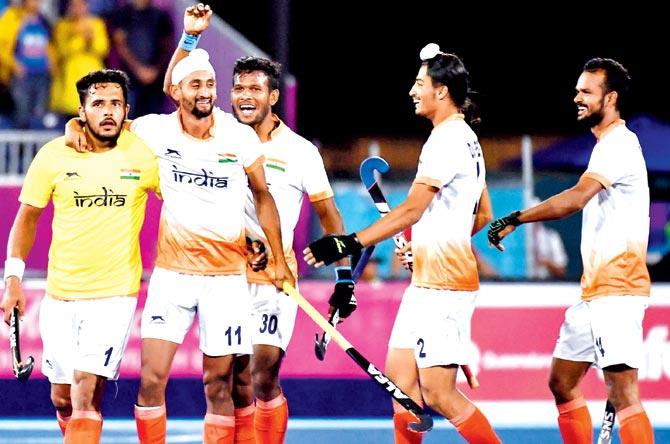 Indian players celebrate a goal against England in a Pool 