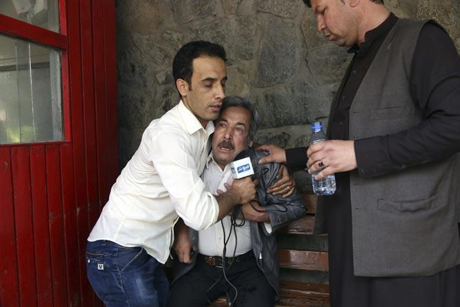 A man cries at a hospital after he lost his Journalist son in explosions in Kabul, Afghanistan