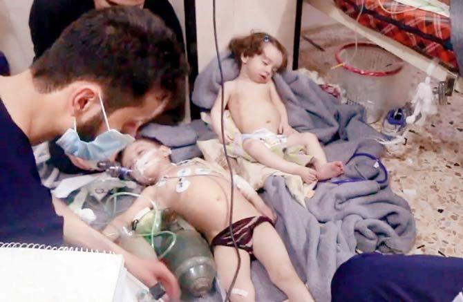 This image, made from video released by the Syrian Civil Defense White Helmets, shows medical workers treating toddlers following the alleged poison gas attack in Douma. Pic/AFP