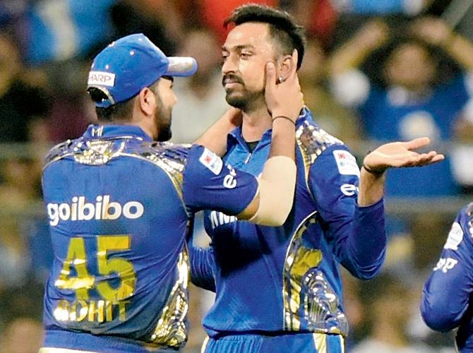Mumbai spinner Krunal Pandya (right) celebrates with skipper Rohit Sharma after dismissing Bangalore’s Corey Anderson at the Wankhede Stadium on Tuesday. Pic/Suresh Karkera