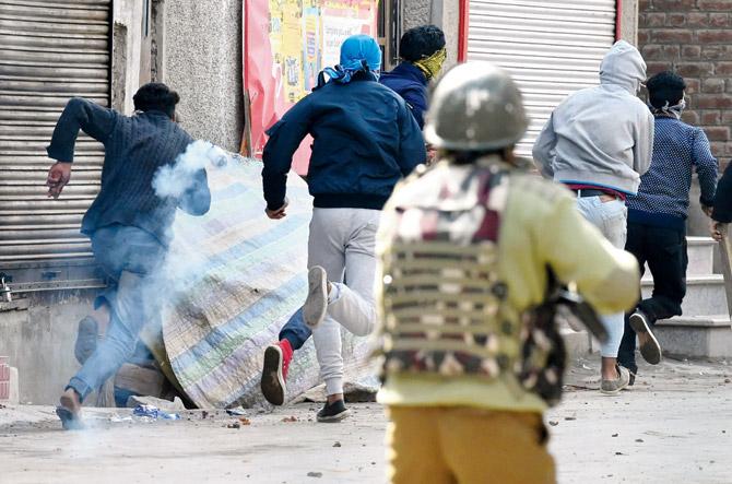 Kashmiri protestors run after police fire tear gas shells during a strike called by Kashmiri separatists against recent killings in Srinagar, on Tuesday. Pic/AFP