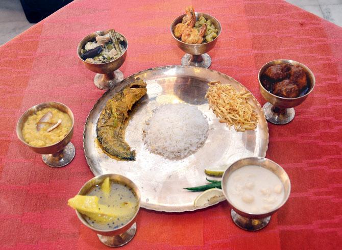 (Bowls from left) Aamer tok, chholar dal, shukto, lau chingri, kosha mangsho, chhanar payesh; on plate: (from left) shorshe pabda, (right) aloo jhuri bhaja, (bottom) gondhoraj pebu and lonka; (centre) rice with Jharna ghee. Pics/Sayyed Sameer Abedi
