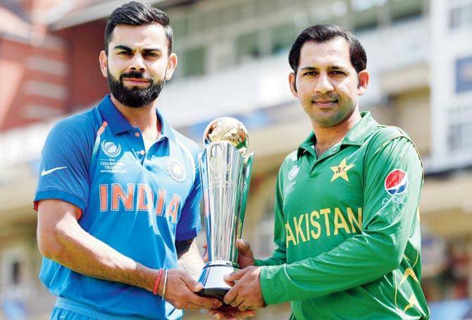India captain Virat Kohli and Pakistan captain Sarfraz Ahmed hold the ICC Champions Trophy at the Kennington Oval in London ahead of the final in June last year. Pakistan eventually won the summit clash by 180 runs. Pic/Getty Images