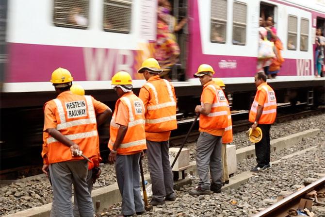 Commuters look by as the gangmen go about with their works