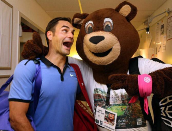 Roger Federer getting goofy with a teddy bear. He grew up in Birsfelden, Riehen, and then Mü,nchenstein, close to the French and German borders, and he speaks Swiss German, Standard German, English and French fluently, as well as functional Italian and Swedish, Swiss German is his native language. Federer served as a ball boy at his hometown Basel tournament, the Swiss Indoors, in 1992 and 1993