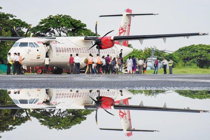 A passenger plane lands at INS Garuda naval base in flood-hit Kochi as the airport is shut due to flooding. Pic/PTI