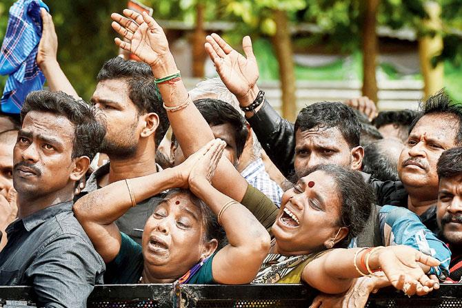DMK workers mourn the death of their party chief Karunanidhi at Rajaji Hall on Wednesday