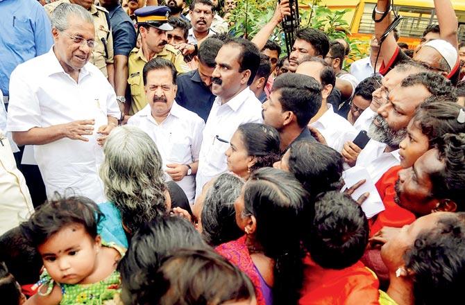 Kerala CM Pinarayi Vijayan interacts with the flood-affected people at a relief camp in Ernakulam