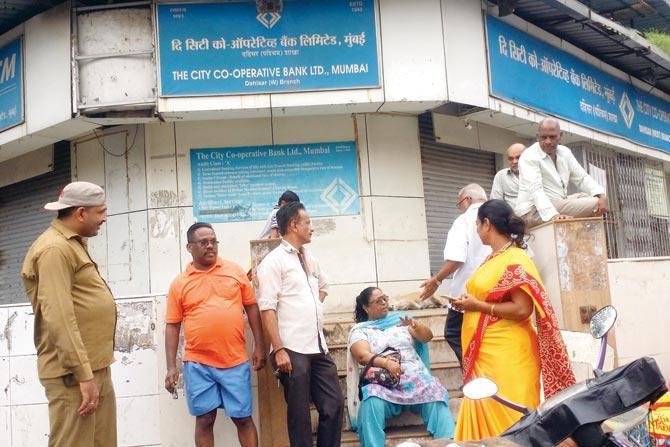 Customers wait outside the bank for news of their money