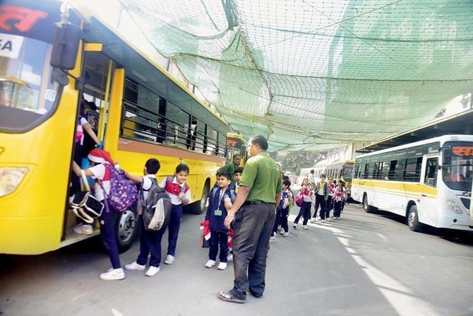 Parents worry about children crossing the road to board buses even as cars drive by disregarding the school guard. Pics/Sameer Markande