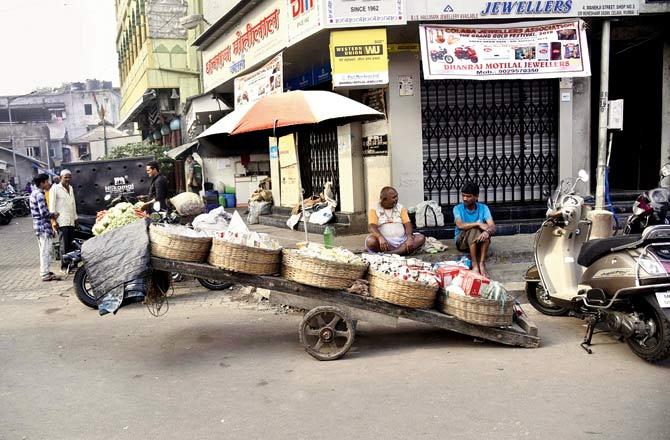 A wooden cart in Colaba market with straw baskets caught Wong