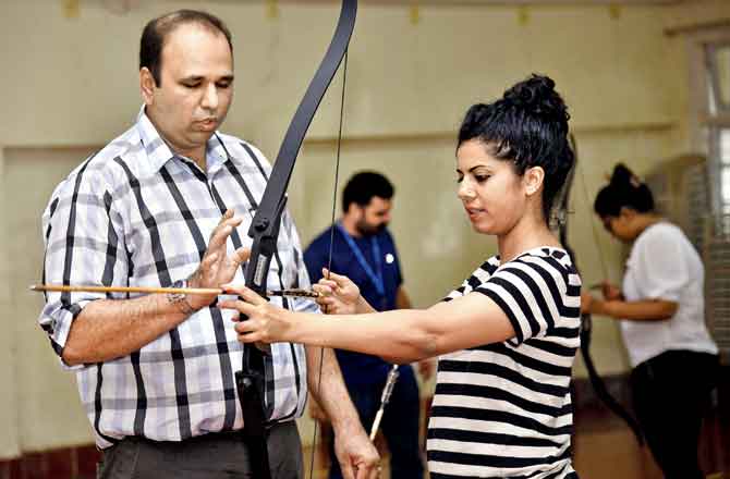 mid-day writers try their hand at archery. As exercise, we are asked to pull the string back and hold. Pics/Pradeep Dhivar
