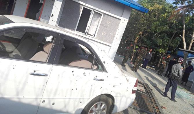 Members of the military (R) stand guard next to a damaged car (L) after an early morning explosion in the compound of the state government secretary