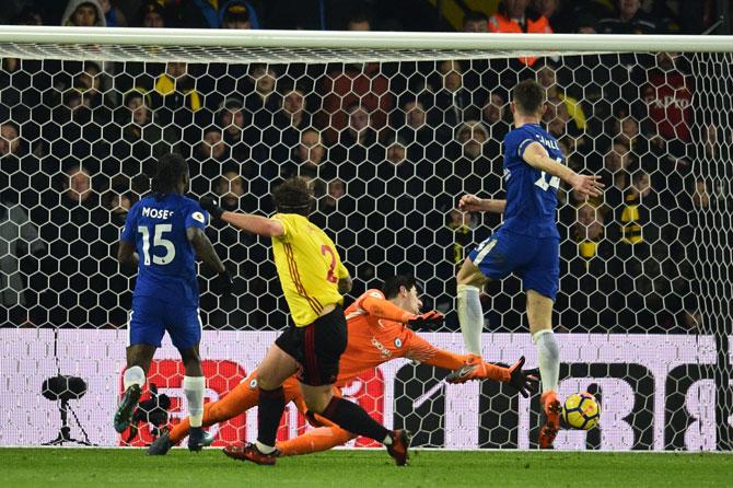 Watfords Dutch defender Daryl Janmaat (2L) scores past Chelseas Belgian goalkeeper Thibaut Courtois during the English Premier League football match between Watford and Chelsea at Vicarage Road Stadium in Watford, north of London on February 5, 2018. Pic/ AFP 