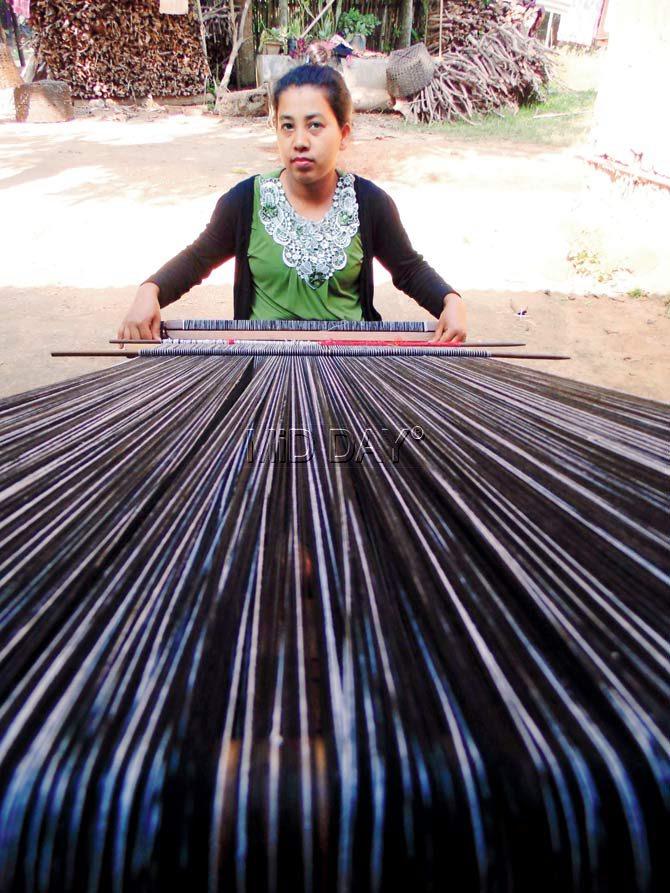 A weaver works with the loinloom for NGO Exotic Echo Society in Nagaland
