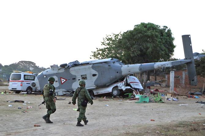 Soldiers of the Mexican army walk in front of the rugged military helicopter and van in Santiago Jamiltepec, Oaxaca state, Mexico, on February 17, 2018. A 7.2-magnitude earthquake rattled Mexico on Friday, causing little damage but triggering a tragedy when a minister