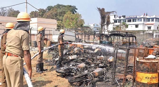 Firemen douse a fire after protesters set ablaze Ainthapali police station and pelted stones at cops in Sambalpur. Pic/PTI