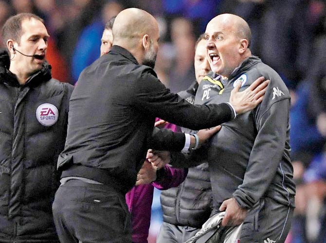 City boss Pep Guardiola (left) argues with Wigan boss Paul Cook during the FAâu00c2u0080u00c2u0088Cup match