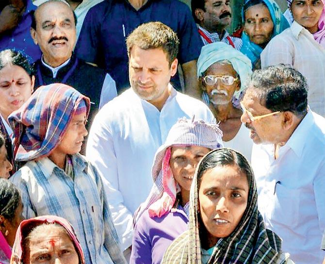 Rahul Gandhi interacts with daily wage workers. Pic/PTI