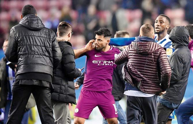 Man City forward Sergio Aguero (centre) gets into a scuffle with Wigan fans after the FA Cup encounter on Monday. Pic/Getty Images