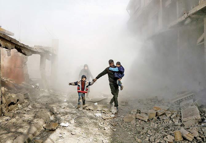 Syrian civlians flee from the regime air strikes on the  outskirts of Damascus. PIC/AFP