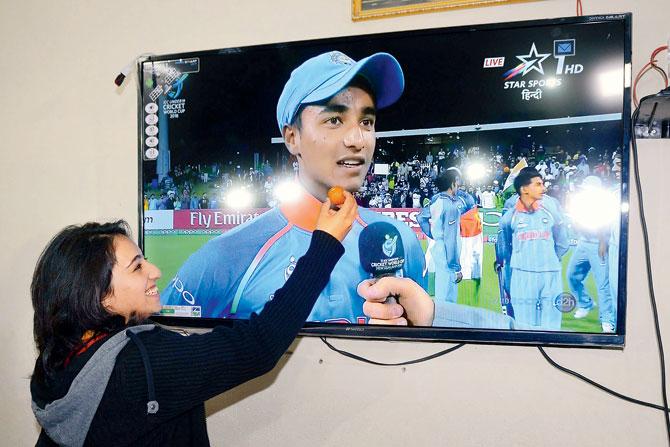 India U-19 World Cup-winning player Abhishek Sharmas sister Saniya offers a sweet to the television image of her brother as the family celebrates the teams victory in Amritsar. PIC/AFP