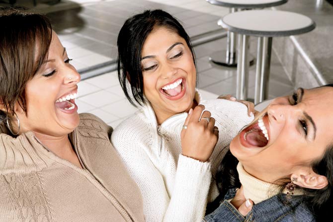 High angle view of three young women laughing