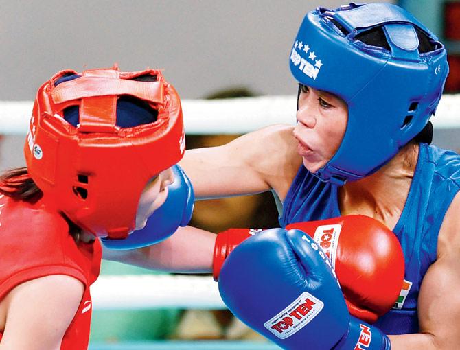 Mary Kom (right) punches Mongolian Altantsetseg Batsaikhan during the light flyweight semis at the India Open yesterday